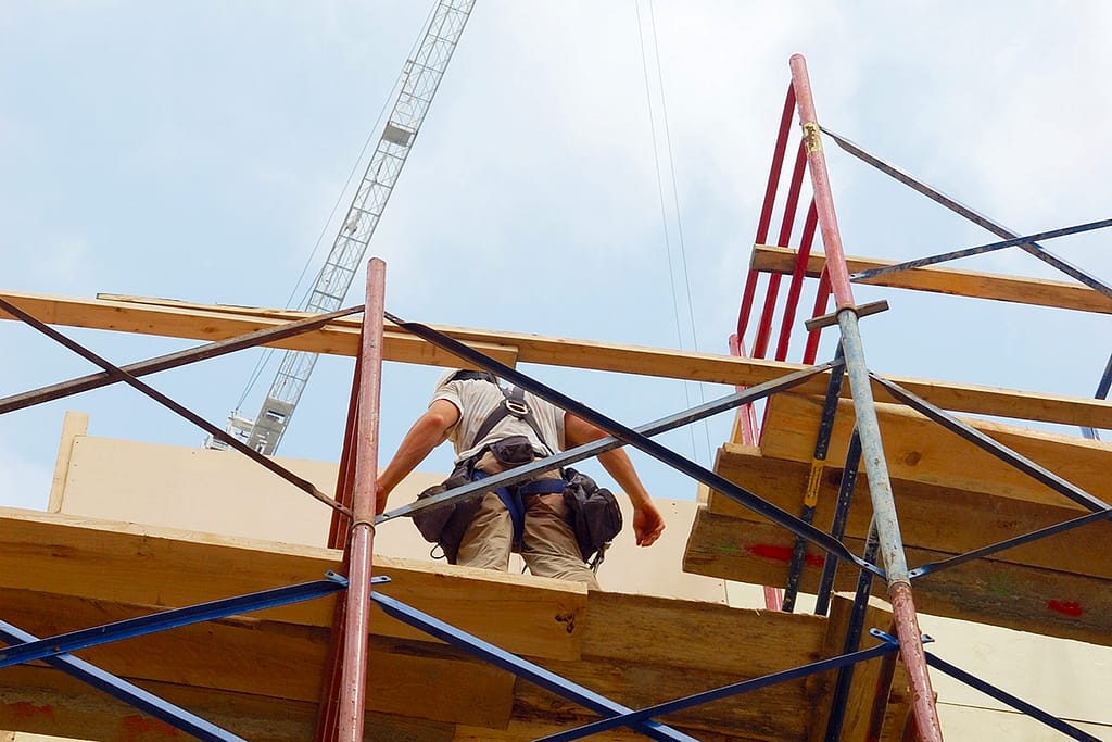Construction worker with safety harness standing at a height